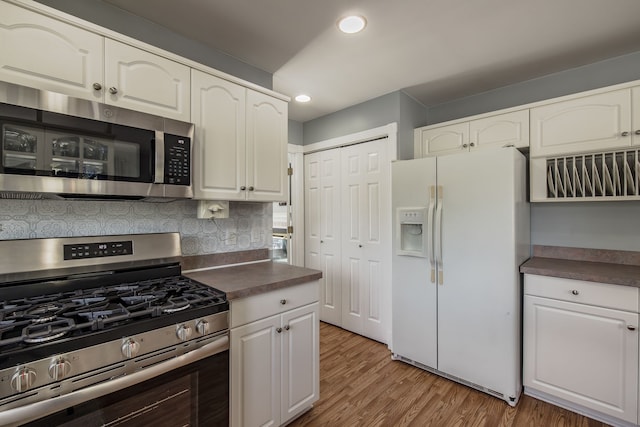 kitchen with white cabinetry, wood-type flooring, stainless steel appliances, and tasteful backsplash