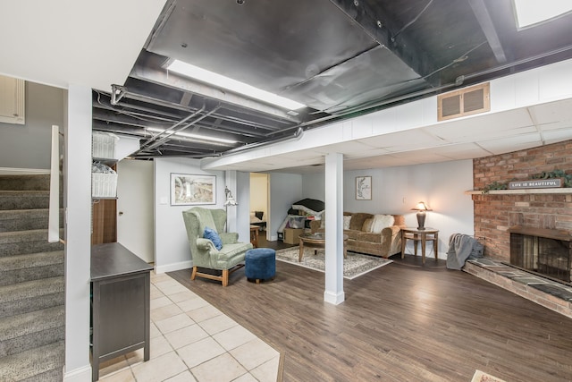 basement featuring a fireplace and light hardwood / wood-style floors