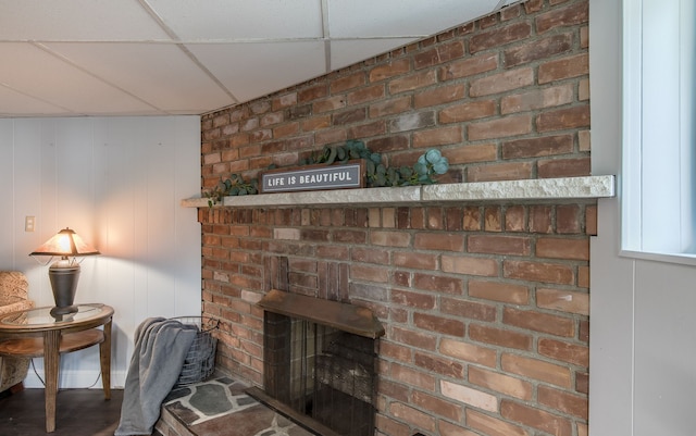 details featuring a fireplace and a drop ceiling