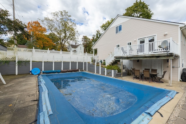 view of swimming pool with a wooden deck and a patio