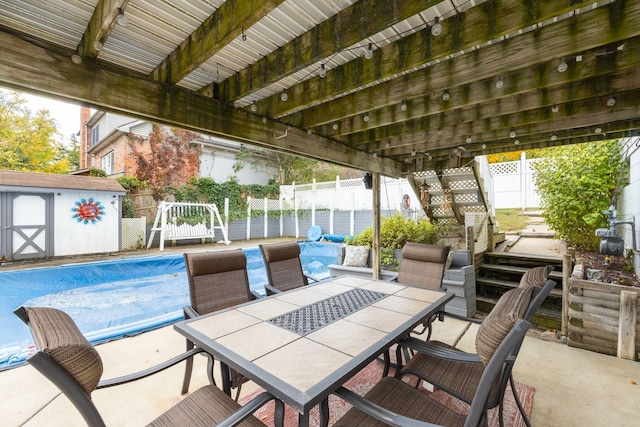 view of patio / terrace with a storage unit and a covered pool