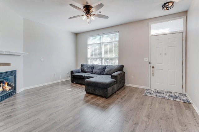 living room featuring light hardwood / wood-style flooring and ceiling fan