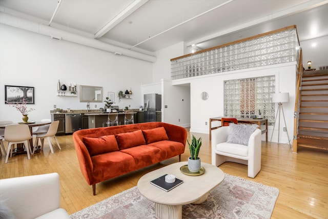 living room with a towering ceiling and light hardwood / wood-style floors