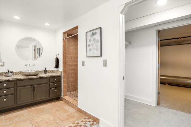 bathroom featuring a tile shower and vanity