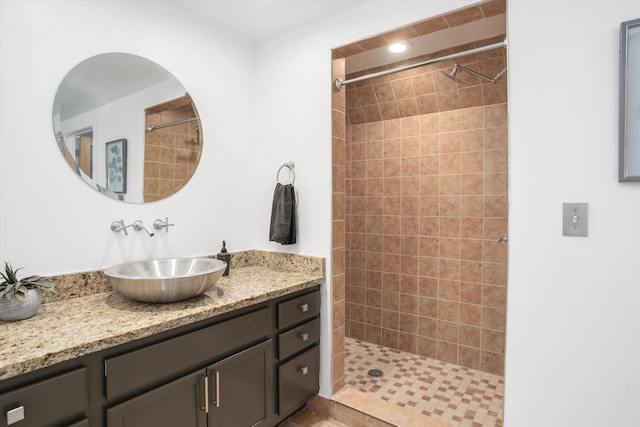 bathroom with vanity and tiled shower