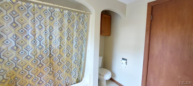 bathroom with a shower with shower curtain and toilet