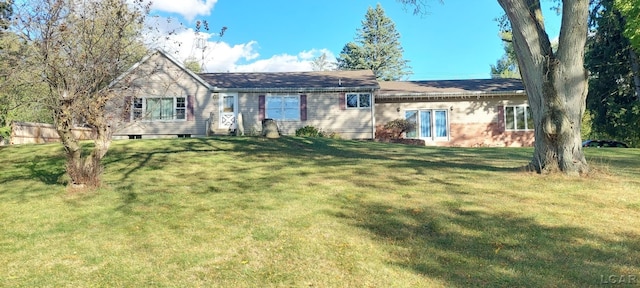 rear view of house featuring a yard