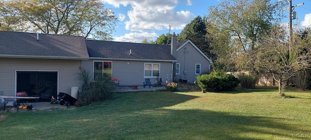 rear view of house featuring a yard