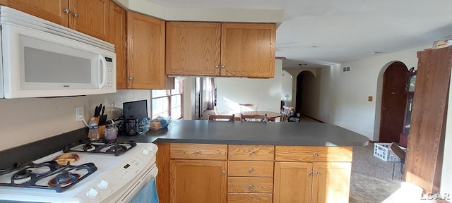 kitchen featuring kitchen peninsula and white appliances