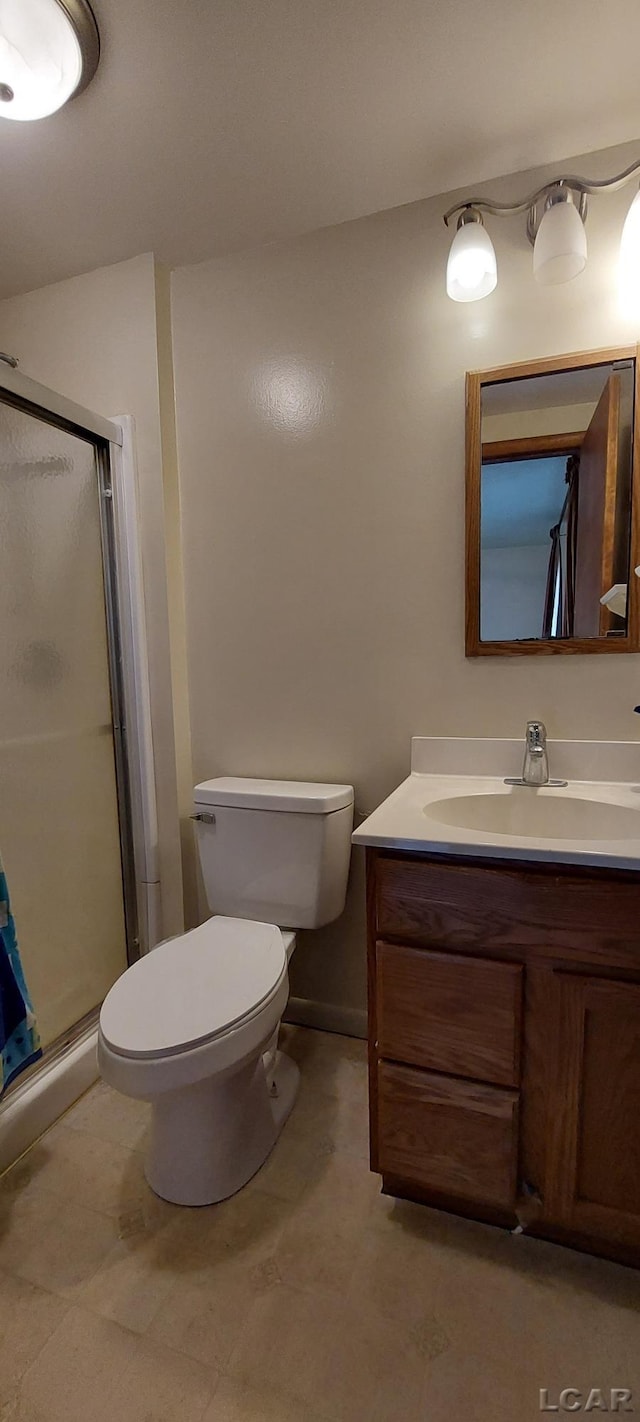 bathroom with vanity, toilet, and an enclosed shower