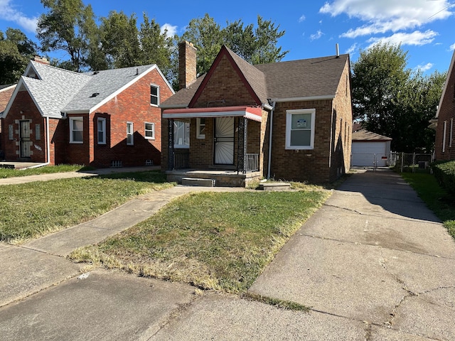 view of front of property with a garage, an outbuilding, and a front yard