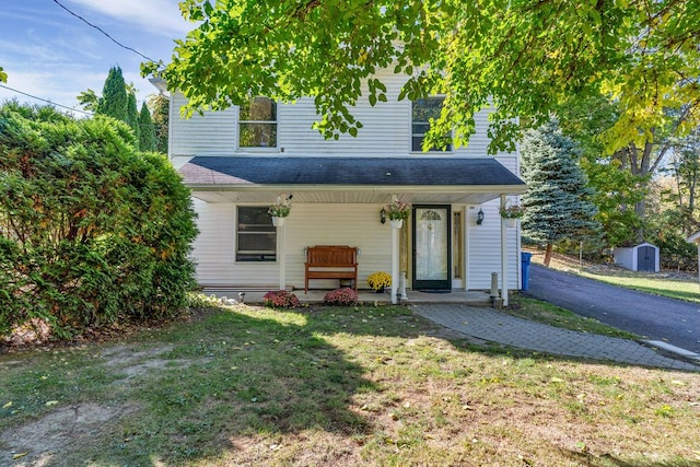 view of front facade featuring a front yard and a storage unit