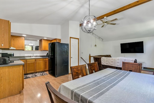 bedroom with high vaulted ceiling, an inviting chandelier, black fridge, sink, and light wood-type flooring