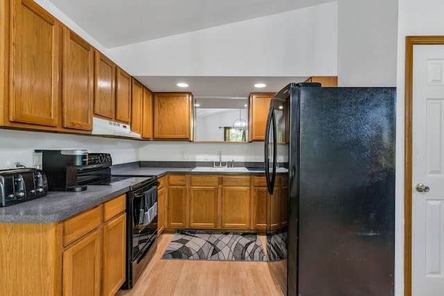 kitchen featuring lofted ceiling, black appliances, sink, light hardwood / wood-style floors, and extractor fan