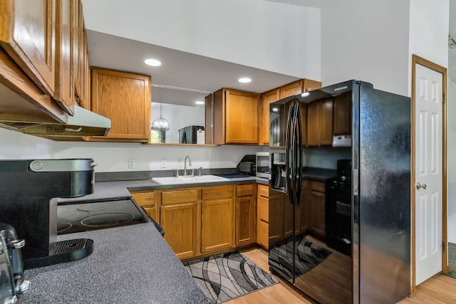 kitchen with black refrigerator with ice dispenser, sink, and light hardwood / wood-style flooring