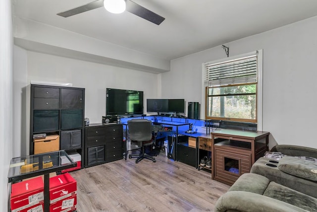 office space featuring a fireplace, ceiling fan, and light hardwood / wood-style flooring