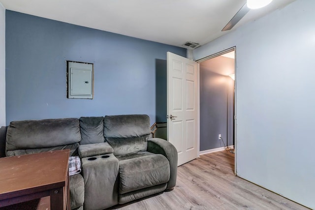 living room featuring electric panel, ceiling fan, and light hardwood / wood-style floors