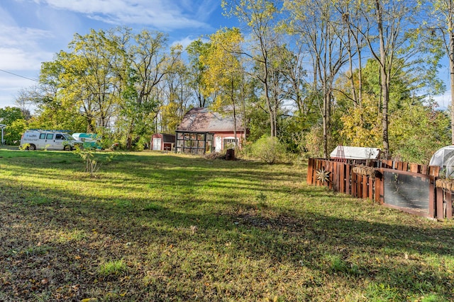 327 Reid Rd, Grand Blanc, MI 48439 - view of yard featuring fence, a shed, and an outbuilding