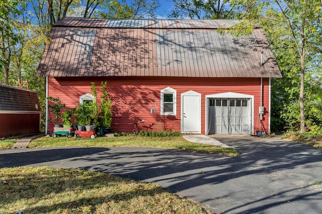 327 Reid Rd, Grand Blanc, MI 48439 - view of front of property featuring an outdoor structure, metal roof, and aphalt driveway