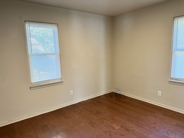 spare room with plenty of natural light and dark wood-type flooring