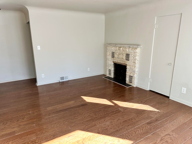 unfurnished living room with a fireplace and dark hardwood / wood-style floors