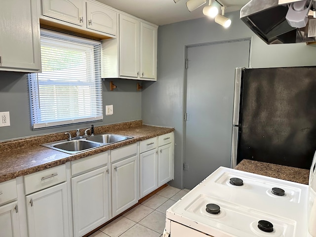 kitchen with white cabinets, ventilation hood, sink, stainless steel fridge, and light tile patterned floors