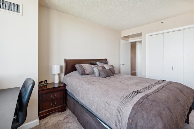 bedroom featuring light carpet, a textured ceiling, and a closet