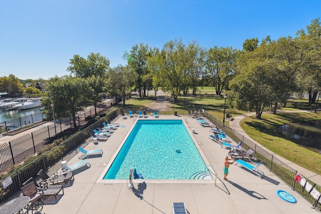 view of swimming pool with a patio area and a water view