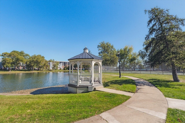 view of dock featuring a gazebo, a water view, and a lawn