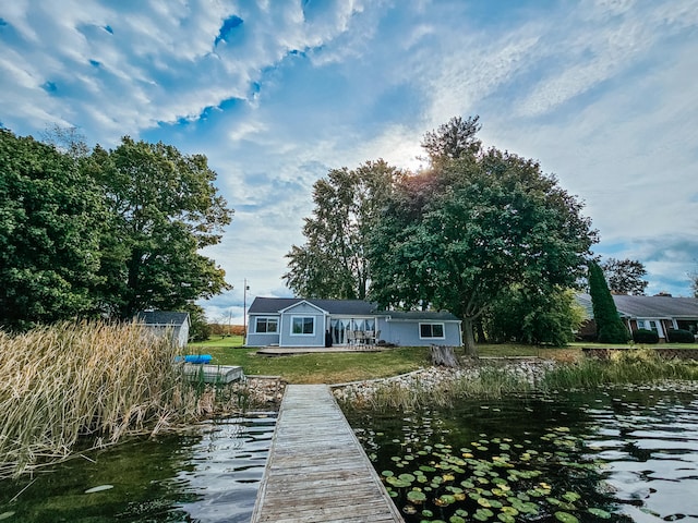 view of dock featuring a water view and a lawn