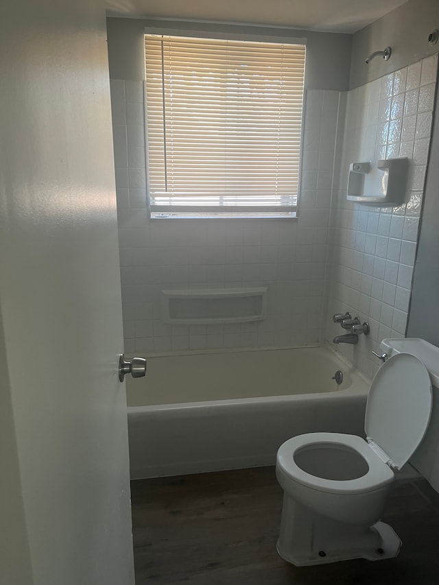 bathroom featuring hardwood / wood-style floors, toilet, and tiled shower / bath