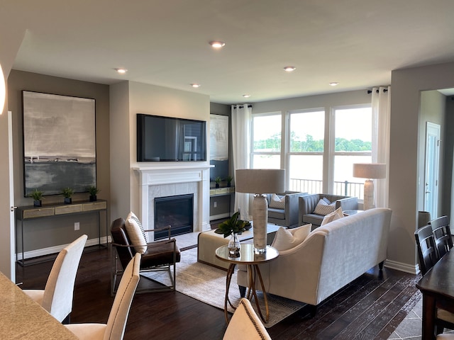 living room featuring a tile fireplace and dark hardwood / wood-style floors