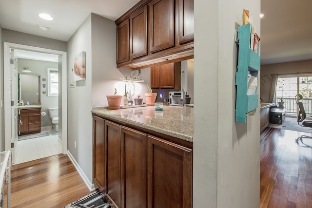 kitchen featuring light stone counters and dark hardwood / wood-style flooring