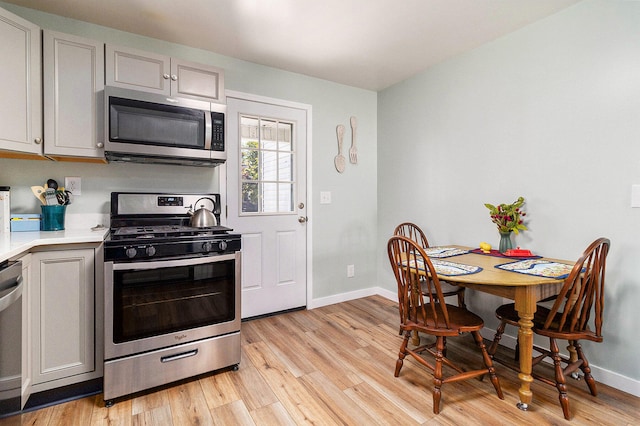 kitchen featuring appliances with stainless steel finishes, gray cabinets, and light hardwood / wood-style flooring