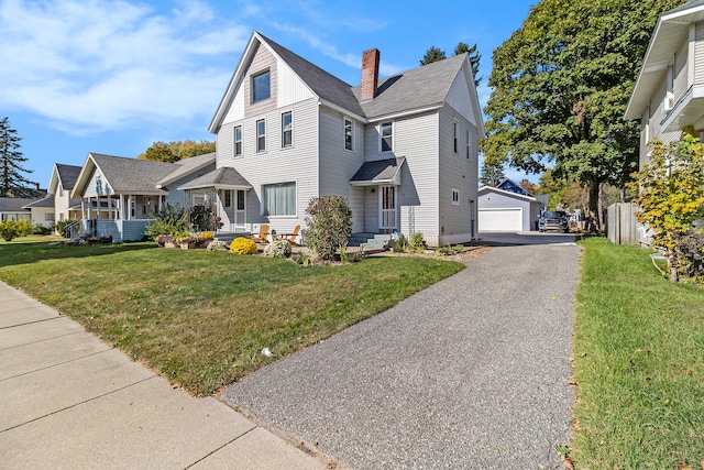 view of front of property featuring an outbuilding, a garage, and a front lawn