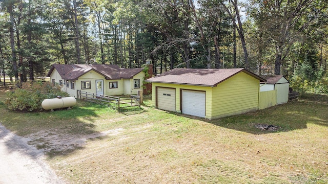 view of front of property with a front yard, an outdoor structure, and a garage