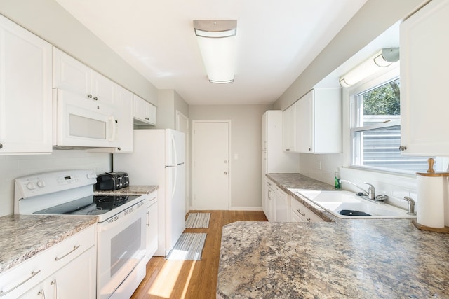 kitchen featuring white appliances, sink, tasteful backsplash, light hardwood / wood-style floors, and white cabinetry