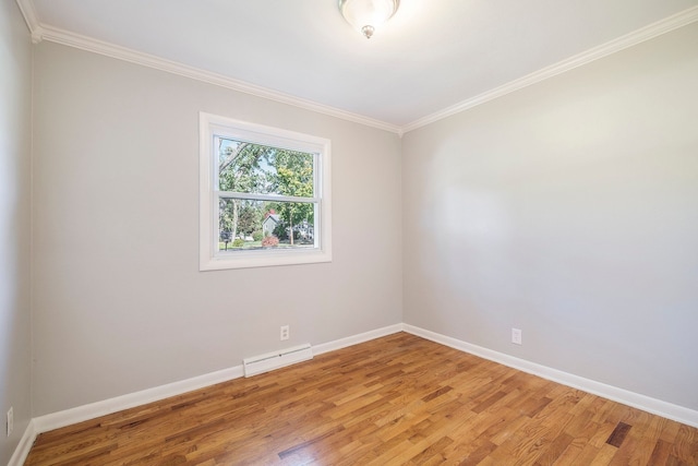 spare room featuring wood-type flooring, ornamental molding, and a baseboard heating unit