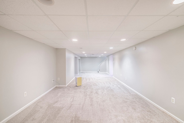 basement with carpet flooring and a paneled ceiling