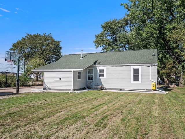 rear view of property featuring a lawn