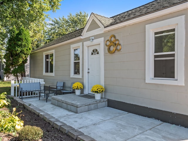 view of exterior entry featuring an outdoor living space and a patio area