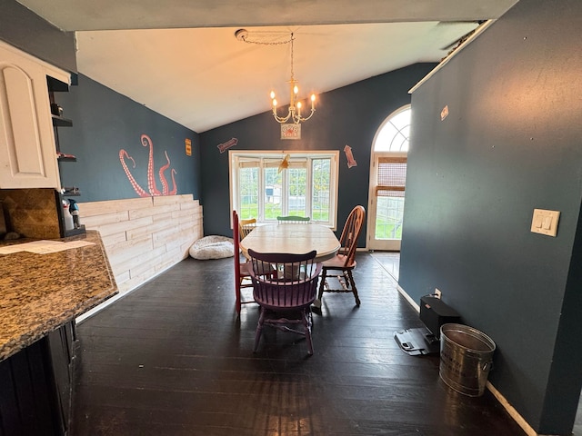 dining space featuring dark hardwood / wood-style flooring, an inviting chandelier, and lofted ceiling