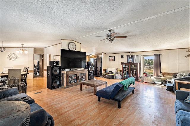 living room with light wood-type flooring, a textured ceiling, and ceiling fan with notable chandelier