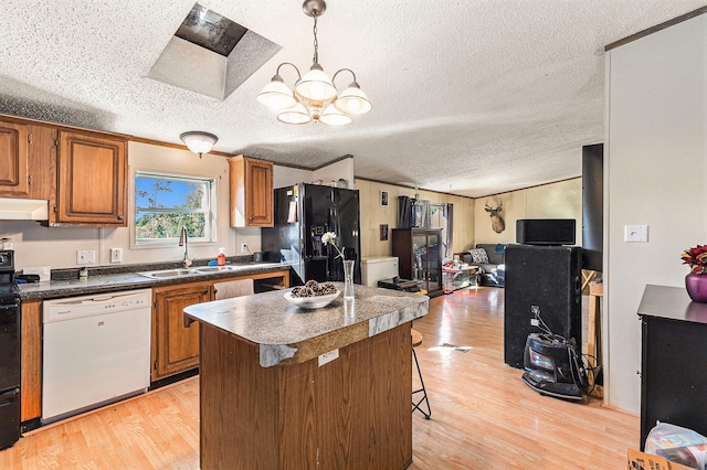 kitchen with a kitchen bar, a textured ceiling, white dishwasher, and black fridge