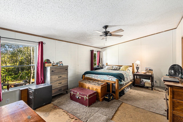 bedroom featuring carpet flooring, ceiling fan, crown molding, and a textured ceiling