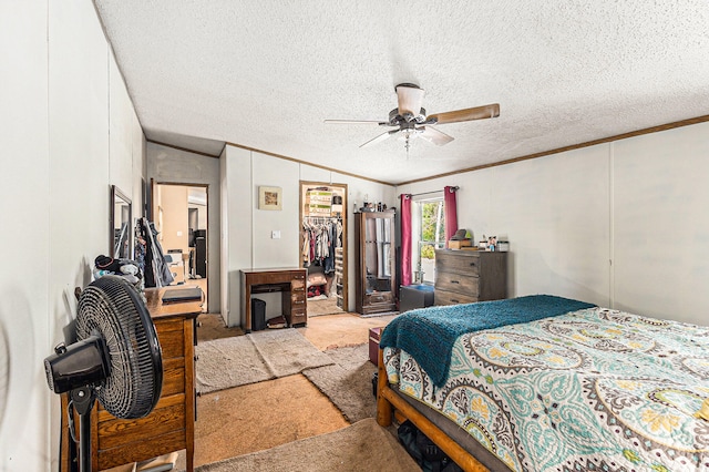 bedroom with a walk in closet, ceiling fan, a textured ceiling, light colored carpet, and a closet