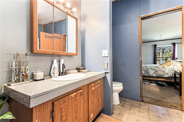 bathroom featuring vanity, toilet, and a textured ceiling