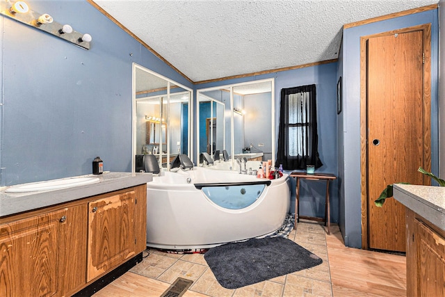 bathroom with crown molding, wood-type flooring, lofted ceiling, a textured ceiling, and vanity