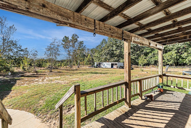 wooden terrace with an outdoor structure and a lawn