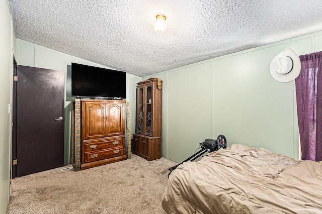 bedroom featuring light carpet and a textured ceiling